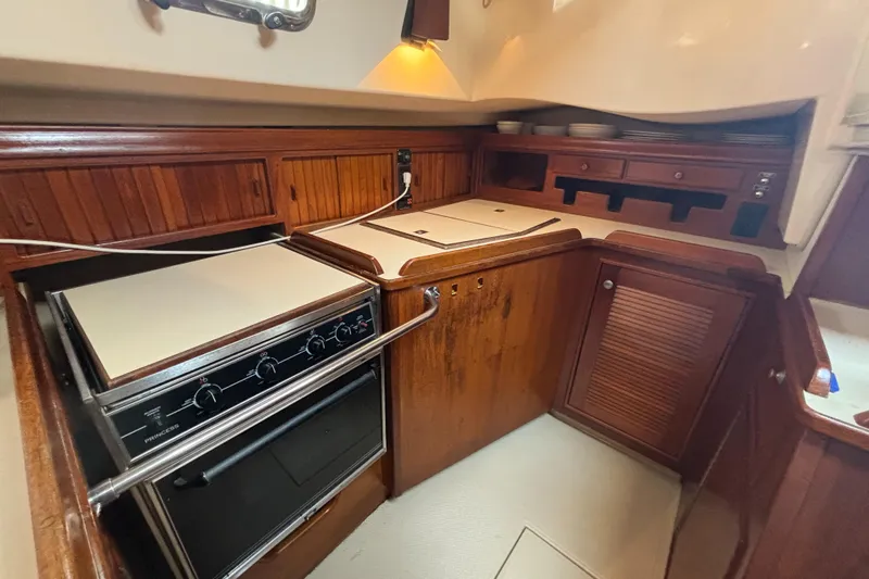 Carpe Diem Yacht Photos Pics Galley kitchen in 1995 Island Packet 40 sailboat with wood cabinetry and stove.