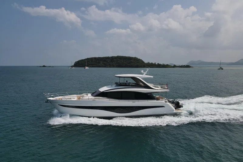 La Mer Yacht Photos Pics Luxurious 2023 Princess Y72 yacht cruising on open sea with scenic island backdrop.