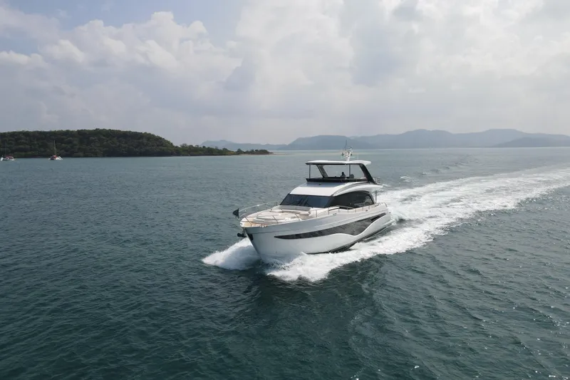 La Mer Yacht Photos Pics 2023 Princess Y72 yacht cruising on open water with scenic island backdrop.