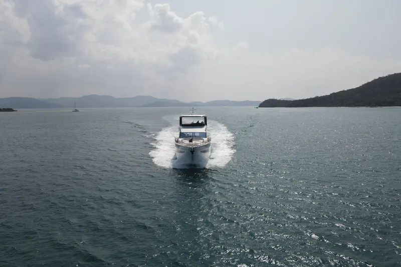 La Mer Yacht Photos Pics 2023 Princess Y72 yacht cruising on open water with scenic mountain backdrop.