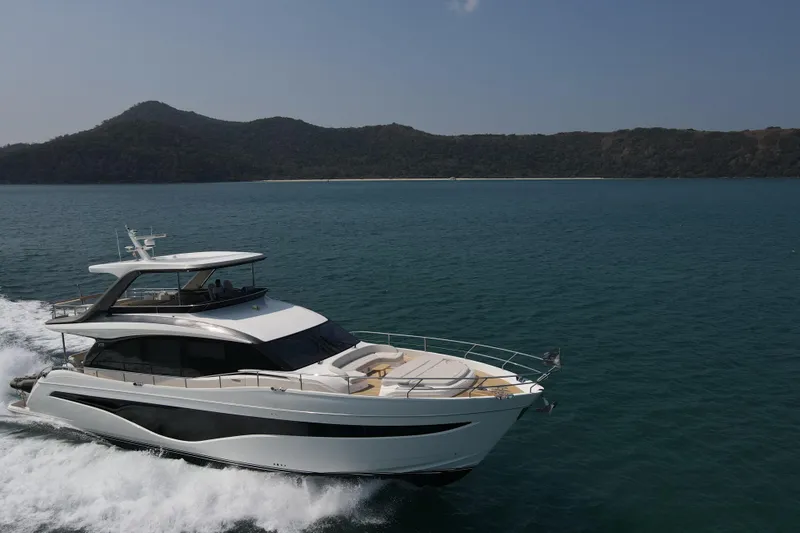 La Mer Yacht Photos Pics Luxury 2023 Princess Y72 yacht cruising on open sea near scenic coastline.