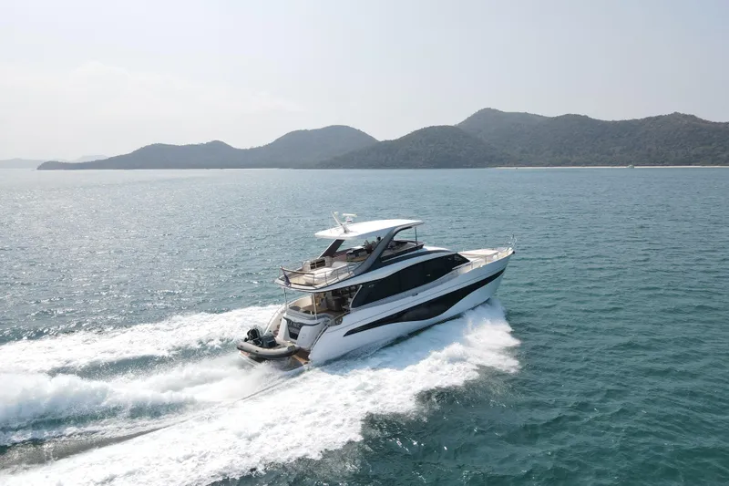 La Mer Yacht Photos Pics 2023 Princess Y72 yacht cruising on open sea with scenic mountain backdrop.