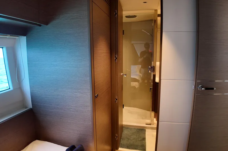 La Mer Yacht Photos Pics Luxurious interior of 2023 Princess Y72 yacht with modern wood paneling and glass door.