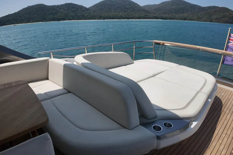 La Mer Yacht Photos Pics Luxurious 2023 Princess Y72 yacht deck with elegant seating, overlooking serene ocean and mountains.