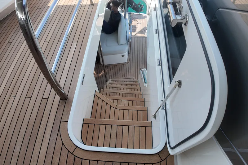 La Mer Yacht Photos Pics Luxurious 2023 Princess Y72 yacht interior with elegant wooden staircase and seating area.