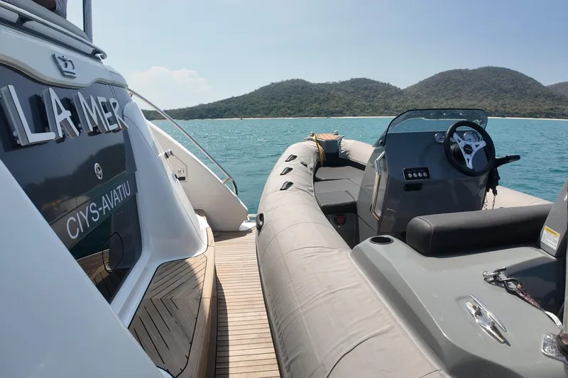 La Mer Yacht Photos Pics Luxury Princess Y72 yacht, 2023 model, docked near scenic coastline with inflatable tender.