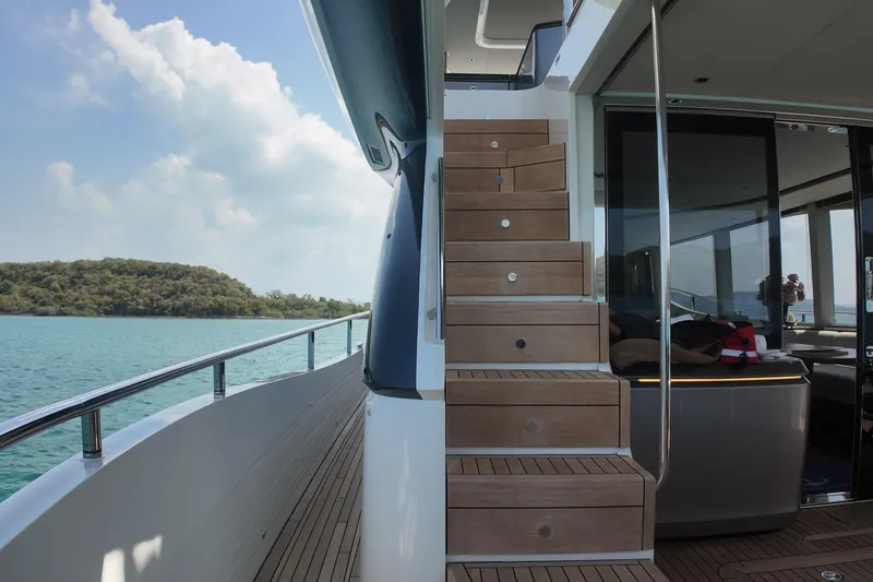 La Mer Yacht Photos Pics Luxurious 2023 Princess Y72 yacht interior with wooden stairs and ocean view.