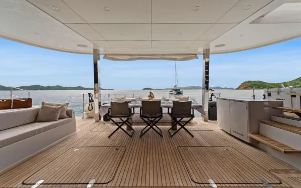 Ocean Vibes Yacht Photos Pics Luxurious Sunreef 70 yacht deck with seating, dining area, and scenic ocean view, 2020 model.