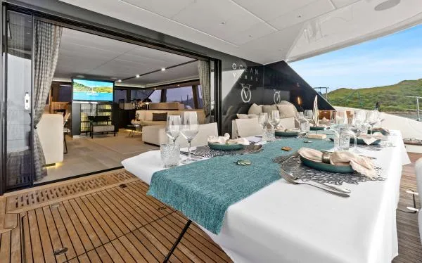 Ocean Vibes Yacht Photos Pics Luxurious Sunreef 70 yacht dining area with elegant table setting and spacious interior, 2020 model.