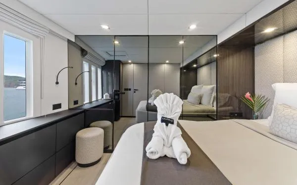 Ocean Vibes Yacht Photos Pics Luxurious Sunreef 70 yacht bedroom interior, featuring elegant decor and a folded towel swan.
