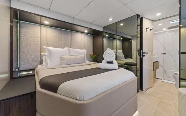 Ocean Vibes Yacht Photos Pics Luxurious bedroom interior on 2020 Sunreef 70 yacht, featuring elegant bedding and modern design.