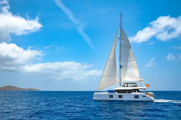 Ocean Vibes Yacht Photos Pics Luxury Sunreef 70 catamaran sailing on open sea under clear blue sky, 2020 model.