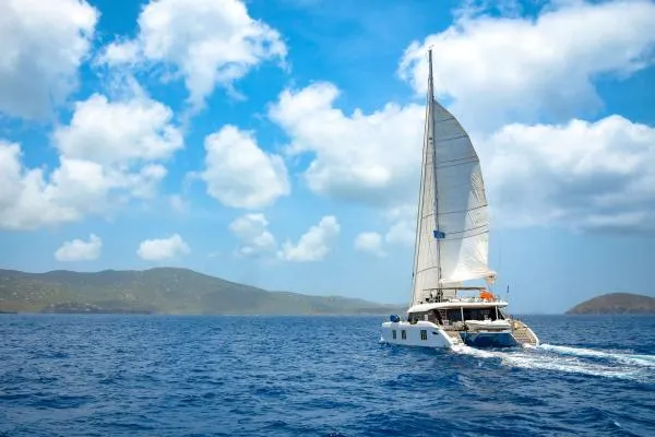 Ocean Vibes Yacht Photos Pics Sailing catamaran Sunreef 70, 2020 model, cruising on open sea under blue sky.