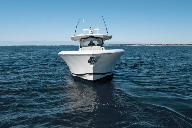 Moore Time Yacht Photos Pics 2023 Pursuit S 428 Sport boat cruising on open water under clear blue sky.