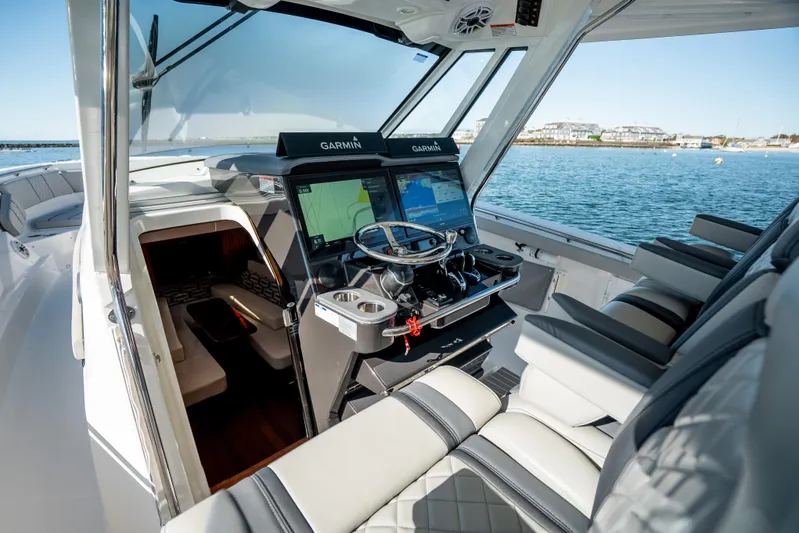 Moore Time Yacht Photos Pics 2023 Pursuit S 428 Sport boat cockpit with Garmin navigation, luxurious seating, and ocean view.