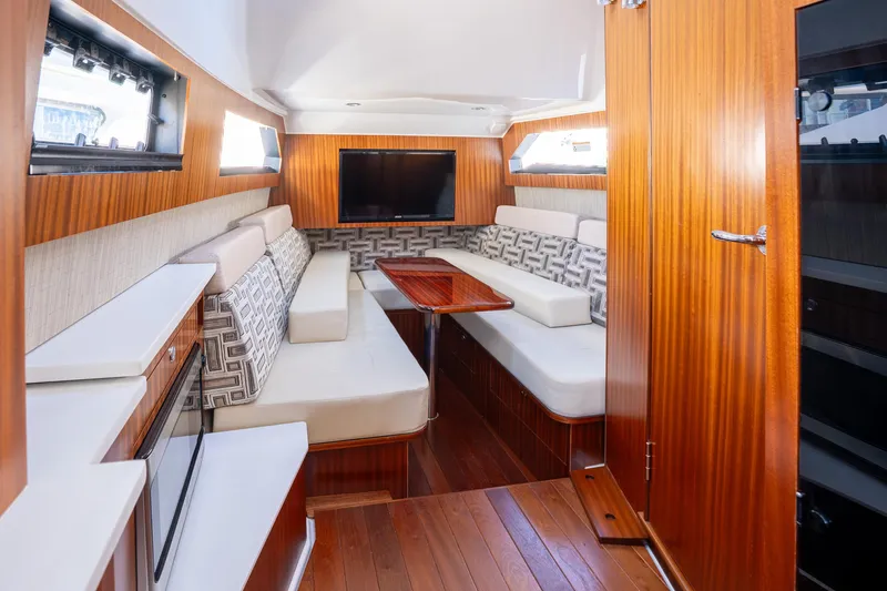 Moore Time Yacht Photos Pics Luxurious interior of 2023 Pursuit S 428 Sport boat with elegant seating and wood finishes.