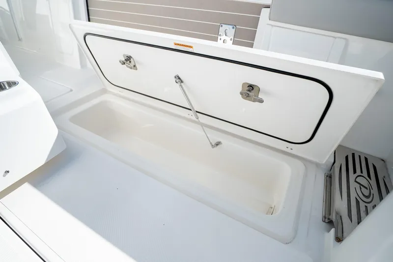 Moore Time Yacht Photos Pics 2023 Pursuit S 428 Sport boat storage compartment open, showcasing interior space.
