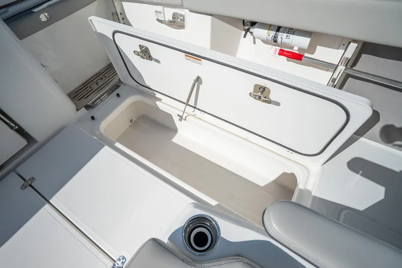 Moore Time Yacht Photos Pics 2023 Pursuit S 428 Sport boat storage compartment with open hatch and fire extinguisher.