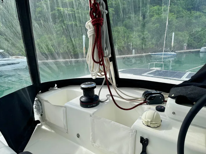 Promprang Yacht Photos Pics Cockpit of 2020 Lagoon 50 catamaran with ropes and winch, docked near lush greenery.