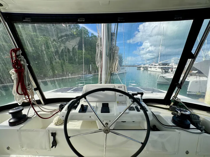 Promprang Yacht Photos Pics Cockpit view of 2020 Lagoon 50 catamaran, featuring steering wheel and marina backdrop.