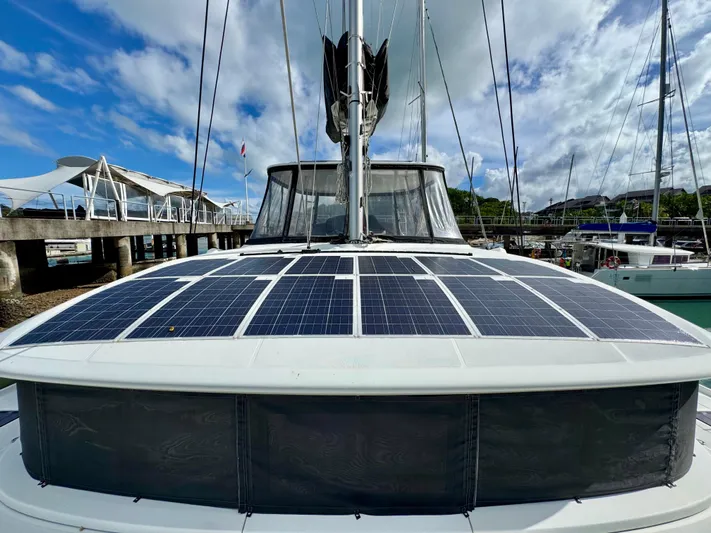 Promprang Yacht Photos Pics 2020 Lagoon 50 catamaran with solar panels docked at marina under blue sky.