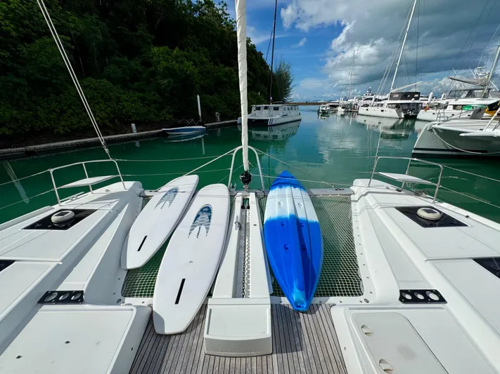 Promprang Yacht Photos Pics Lagoon 50 catamaran with paddleboards docked in a serene marina, 2020 model.