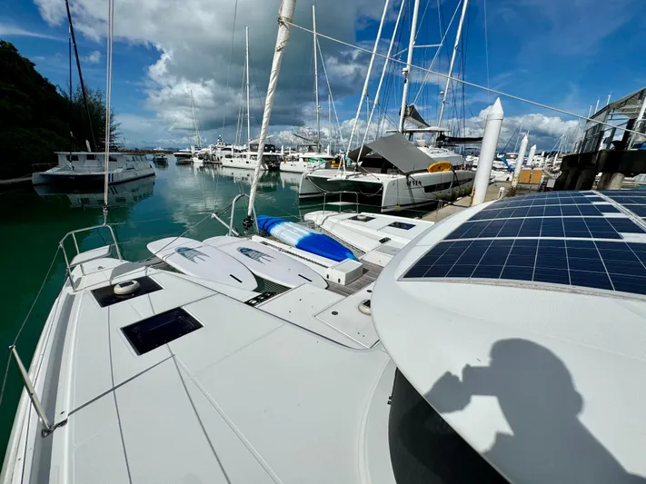 Promprang Yacht Photos Pics 2020 Lagoon 50 catamaran docked in marina with solar panels and clear blue sky.