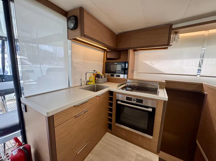 Promprang Yacht Photos Pics Modern kitchen interior on a 2020 Lagoon 50 yacht, featuring sleek wood cabinetry and appliances.
