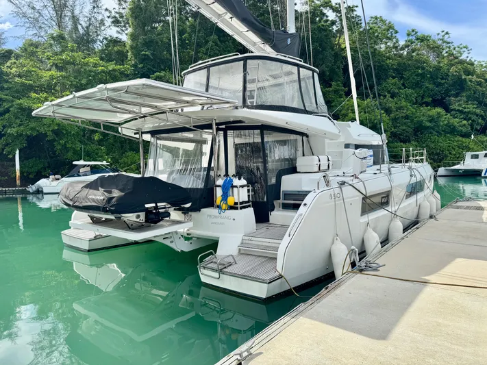 Promprang Yacht Photos Pics 2020 Lagoon 50 catamaran docked in a serene marina setting.