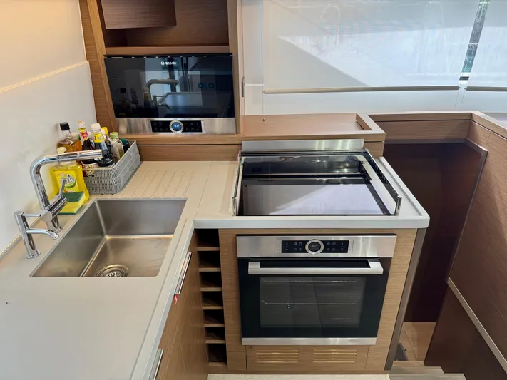 Promprang Yacht Photos Pics Modern kitchen in 2020 Lagoon 50 yacht with stainless steel appliances and wooden cabinetry.