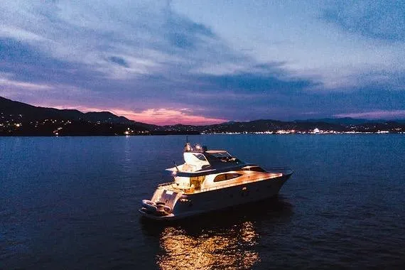  Yacht Photos Pics Luxurious 2005 Canados 72 S yacht illuminated at sunset on tranquil waters.
