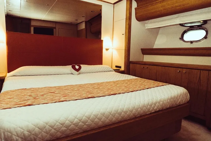  Yacht Photos Pics Luxurious bedroom interior on 2005 Canados 72 S yacht, featuring elegant wood finishes.