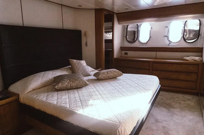  Yacht Photos Pics Luxurious bedroom interior of 2005 Canados 72 S yacht with elegant bedding and porthole windows.