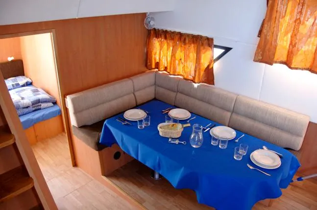 Houseboat Minuetto 6 Yacht Photos Pics Dining area in 2009 Custom Minuetto 6 boat with blue tablecloth and cozy seating.