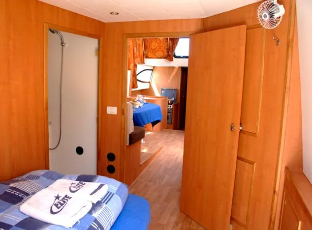 Houseboat Minuetto 6 Yacht Photos Pics Interior of 2009 Custom Minuetto 6 boat with cozy bedroom and wooden decor.