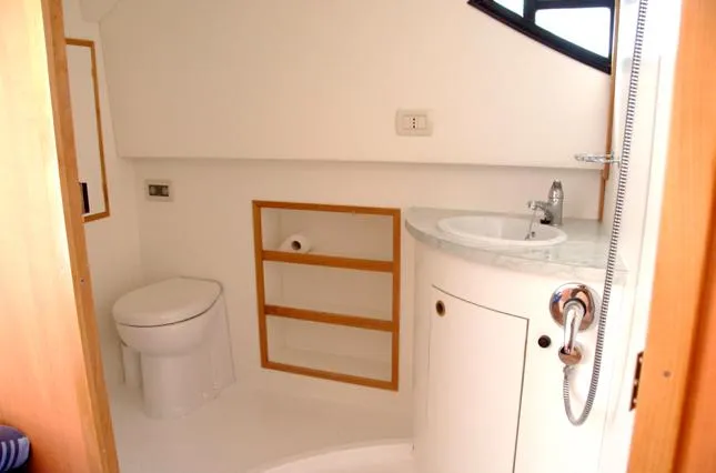 Houseboat Minuetto 6 Yacht Photos Pics Compact bathroom in 2009 Custom Minuetto 6 boat with sink, toilet, and storage shelves.