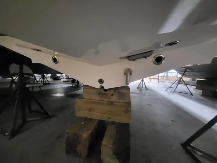  Yacht Photos Pics 2022 Fountain 38 SC boat hull on wooden blocks in storage.