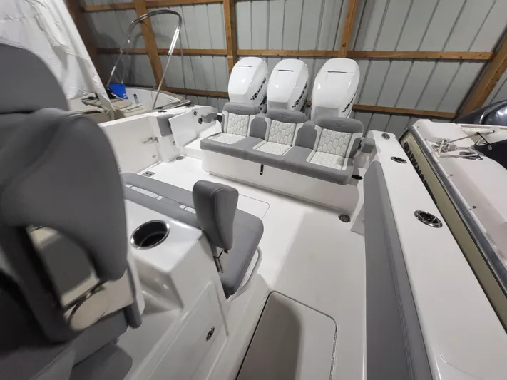  Yacht Photos Pics 2022 Fountain 38 SC boat interior with triple engines and seating in a storage facility.