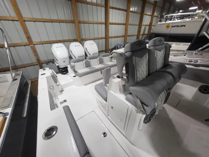  Yacht Photos Pics 2022 Fountain 38 SC boat interior with triple outboard engines in a storage facility.