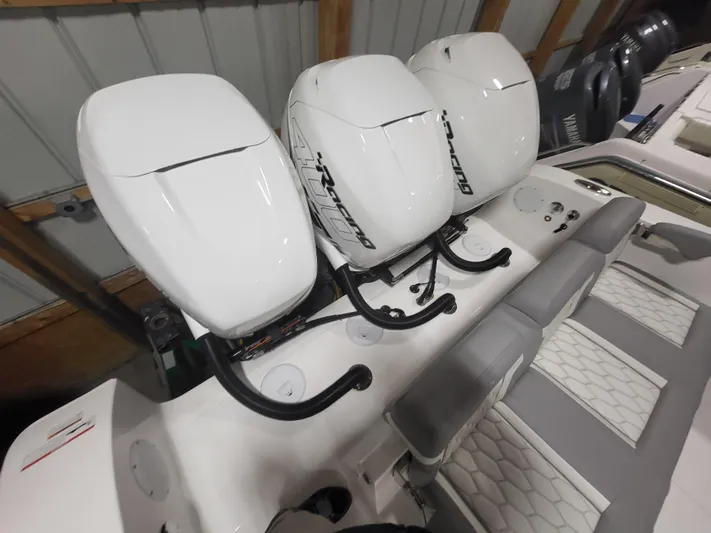  Yacht Photos Pics 2022 Fountain 38 SC boat with triple outboard engines in a storage facility.