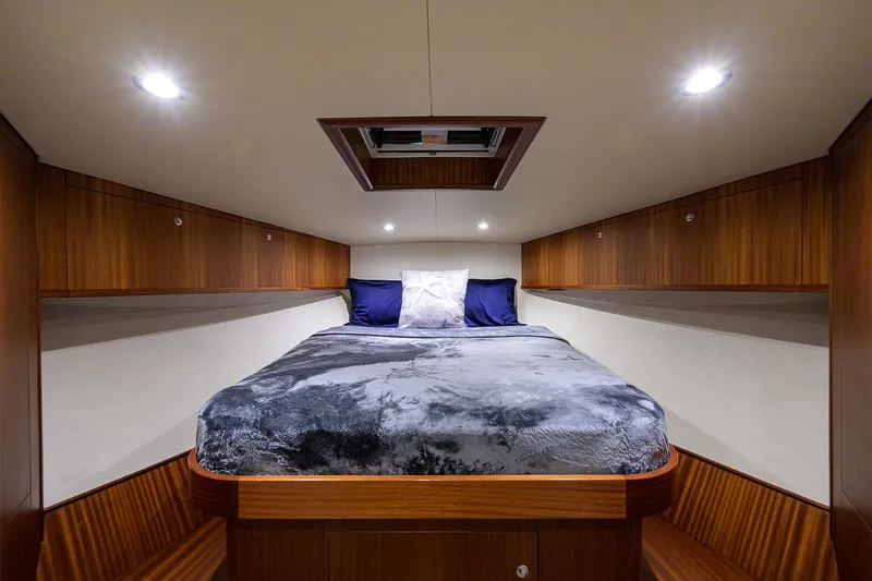  Yacht Photos Pics Luxurious cabin interior of 2022 F&S 58 Custom Carolina yacht with cozy bed and wooden accents.