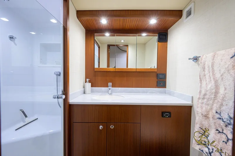  Yacht Photos Pics Luxurious bathroom in 2022 F&S 58 Custom Carolina yacht with modern fixtures and wooden cabinetry.
