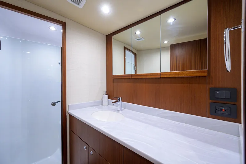  Yacht Photos Pics Luxurious bathroom in 2022 F&S 58 Custom Carolina yacht with modern fixtures and wooden cabinetry.