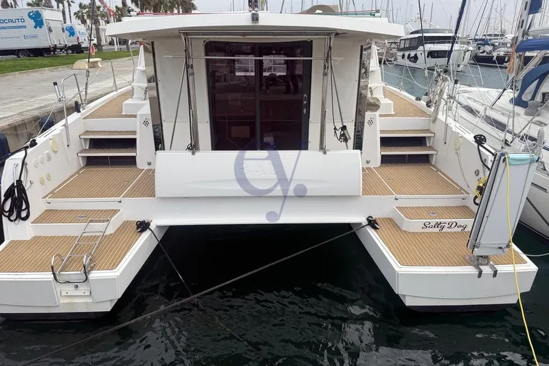  Yacht Photos Pics 2016 Catana Group Bali 4.0 catamaran docked at marina, rear view with wooden deck.