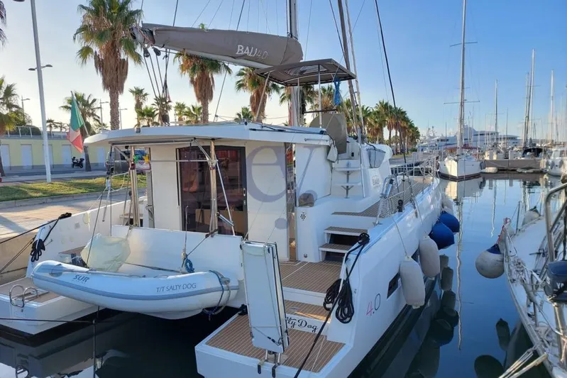  Yacht Photos Pics 2016 Catana Group Bali 4.0 catamaran docked in a marina, surrounded by palm trees.