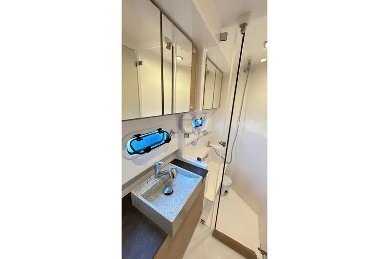  Yacht Photos Pics Bathroom interior of 2016 Catana Group Bali 4.0 catamaran, featuring modern fixtures and porthole window.