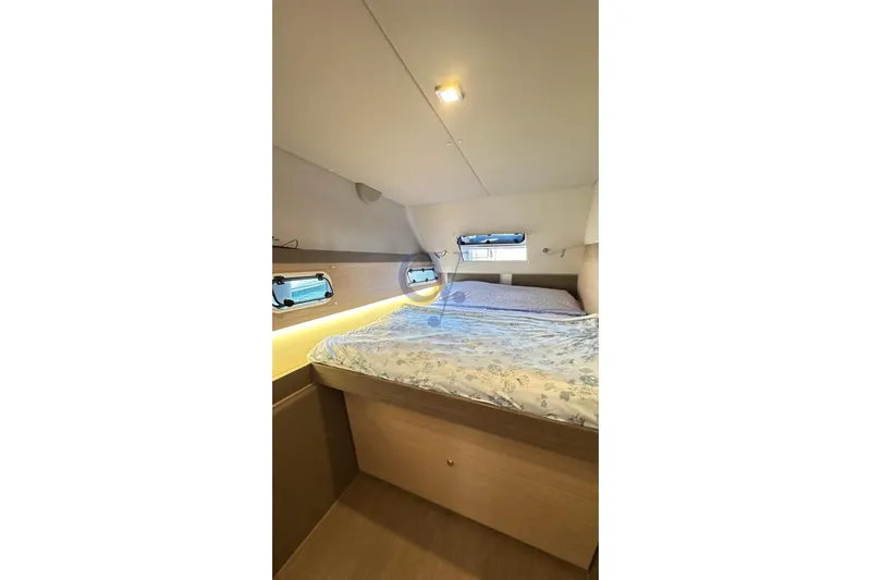  Yacht Photos Pics Interior cabin of 2016 Catana Group Bali 4.0 catamaran with cozy bed and porthole windows.