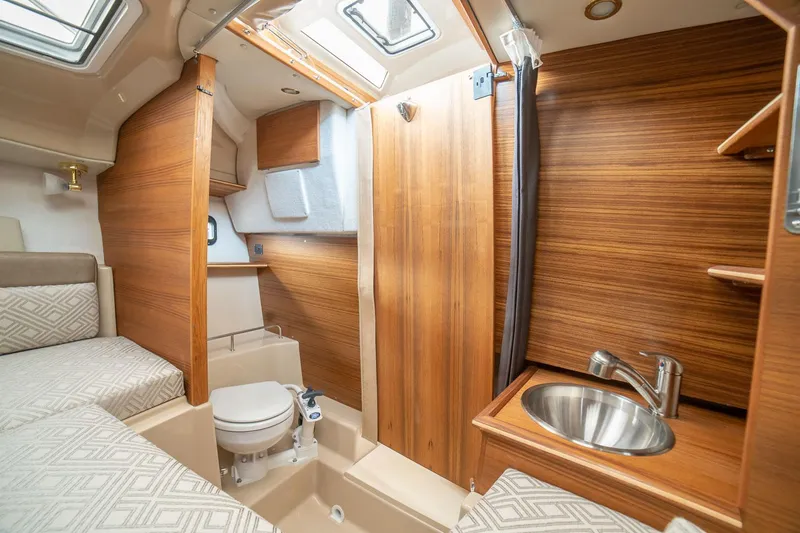  Yacht Photos Pics 2025 Ranger Tugs R-23 interior cabin with wood finish, sink, and toilet.