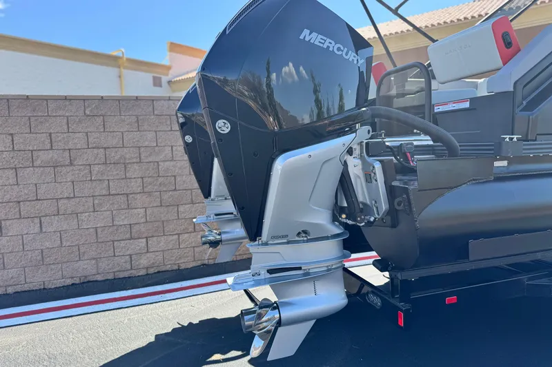  Yacht Photos Pics 2026 Manitou Explore Dual Engine boat with Mercury outboard motors, parked outdoors.