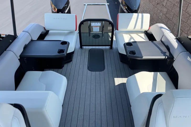  Yacht Photos Pics Luxurious interior of 2026 Manitou Explore Dual Engine boat with comfortable seating and tables.